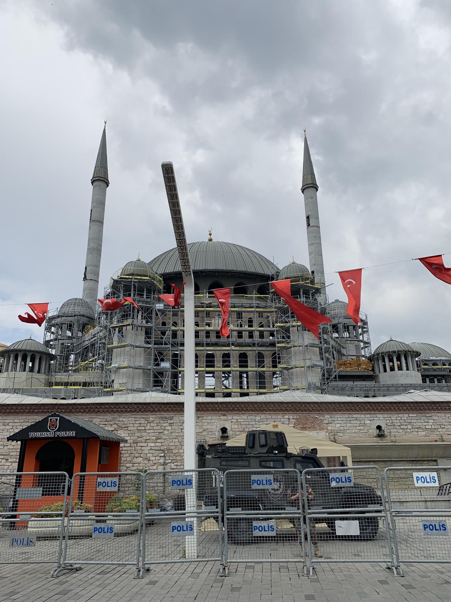 Taksim Mosque's dome and minarets rise up behind a police fence in Istanbul.