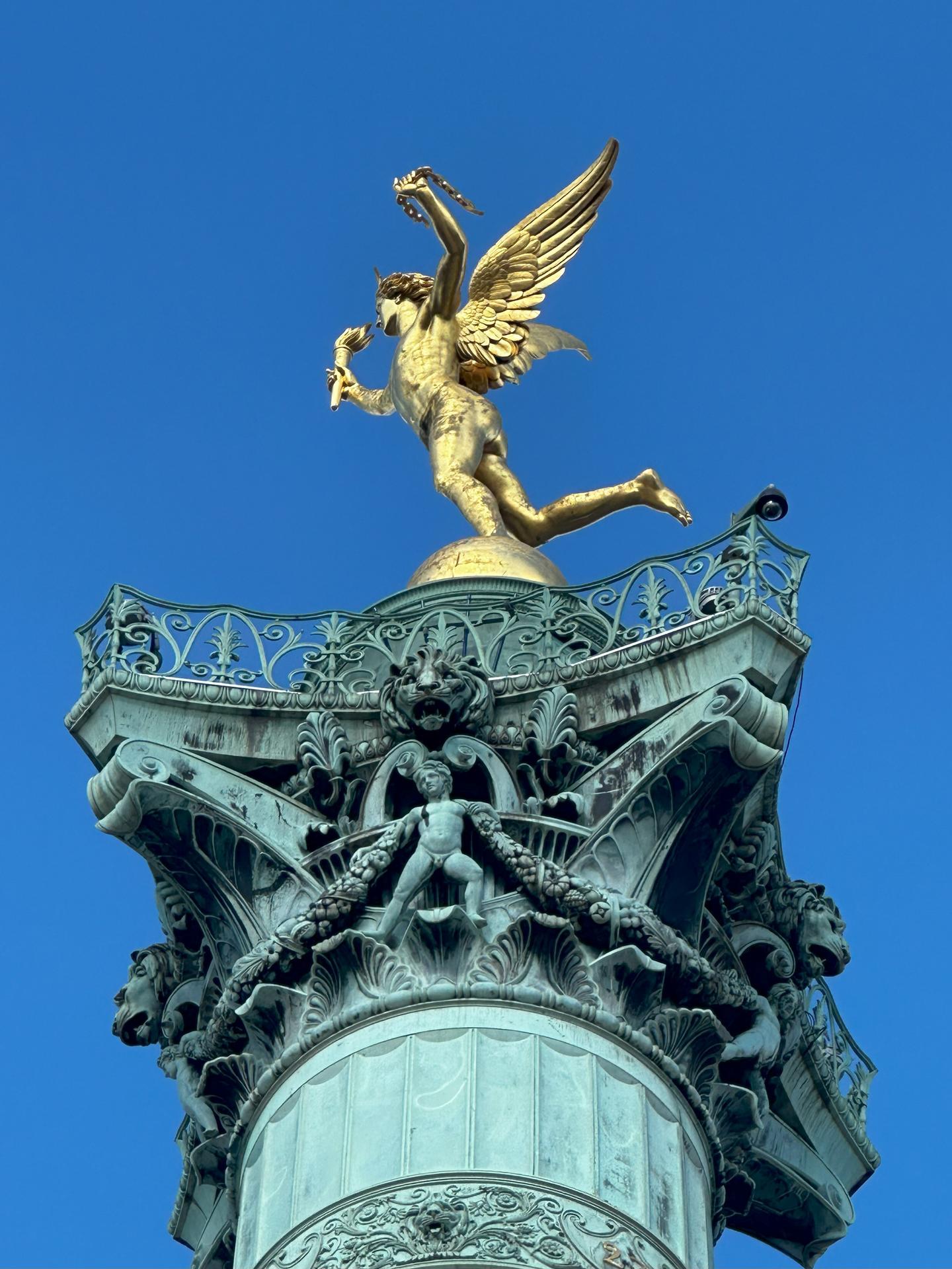 The golden winged statue of the Spirit of Liberty atop the green bronze "Colonne de Juillet" outside of the Bastille in Paris.