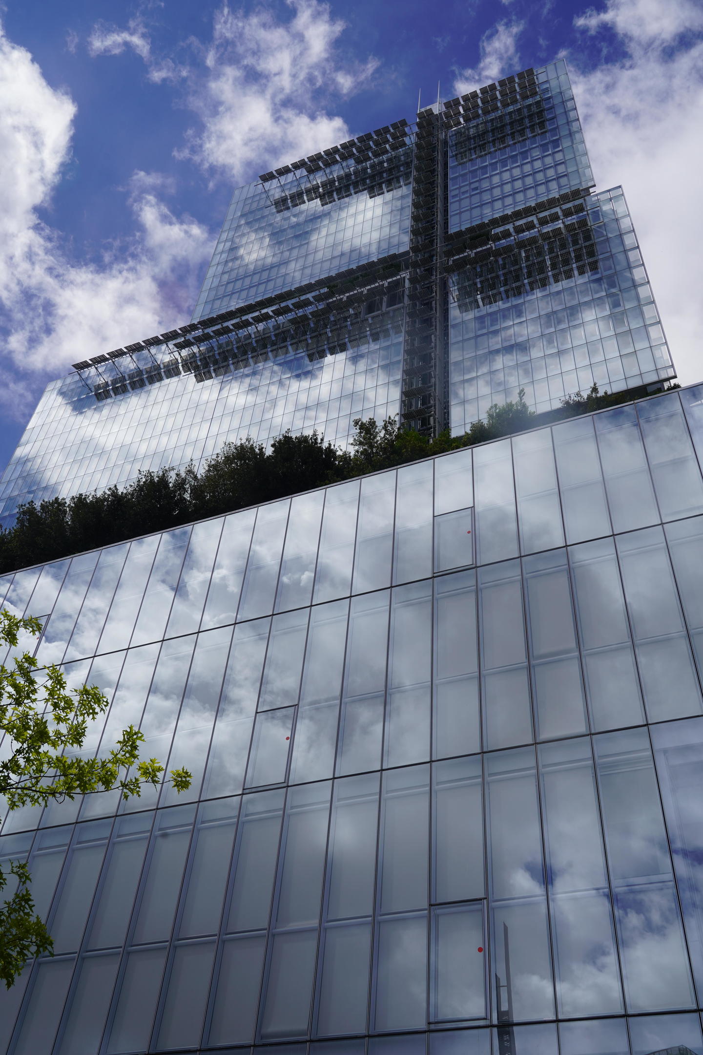 The glass "Palais de Justice" or Paris Tribunal reflects the blue and clouded sky and appears to be invisible, filled with clouds and sky.